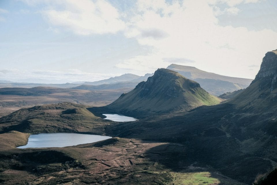 Mountains and lakes sit under a bright sky.
